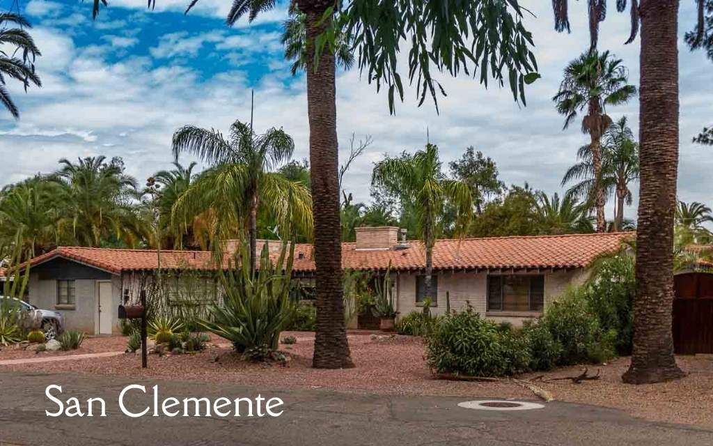 Ranch style home with a tile roof surrounded by palm trees in San Clemente, a historic district in Tucson.