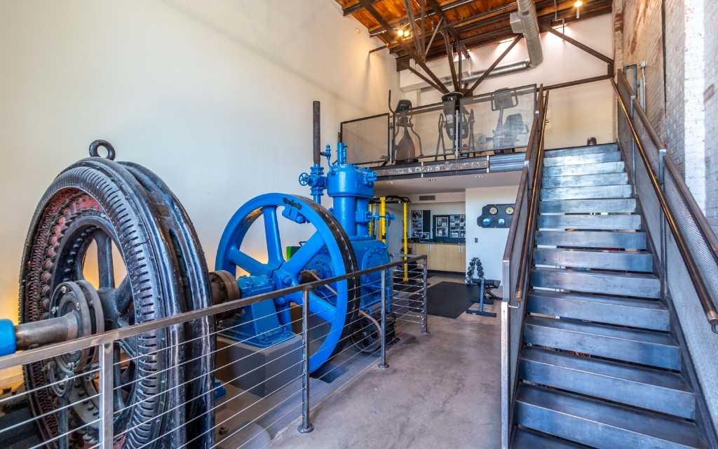 The community includes access to a gym featuring weights on the main level and stationary bikes on the upper loft level. Machinery from the manufacturing days remains as a historic tribute. 