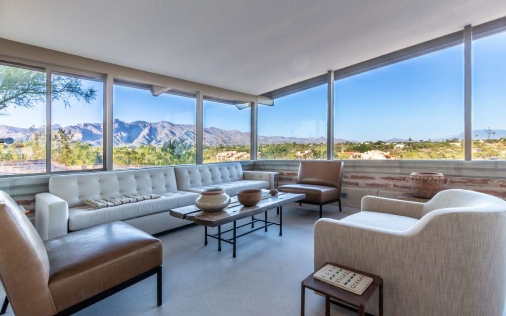 midcentury modern Tom Gist home for sale. Interior living room with large windows and beautiful mountain views